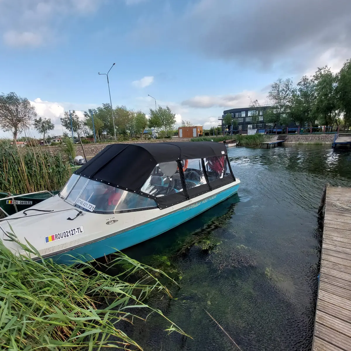 Barca de excursii Corsar 700 pe canal în Delta Dunării, lângă stuf